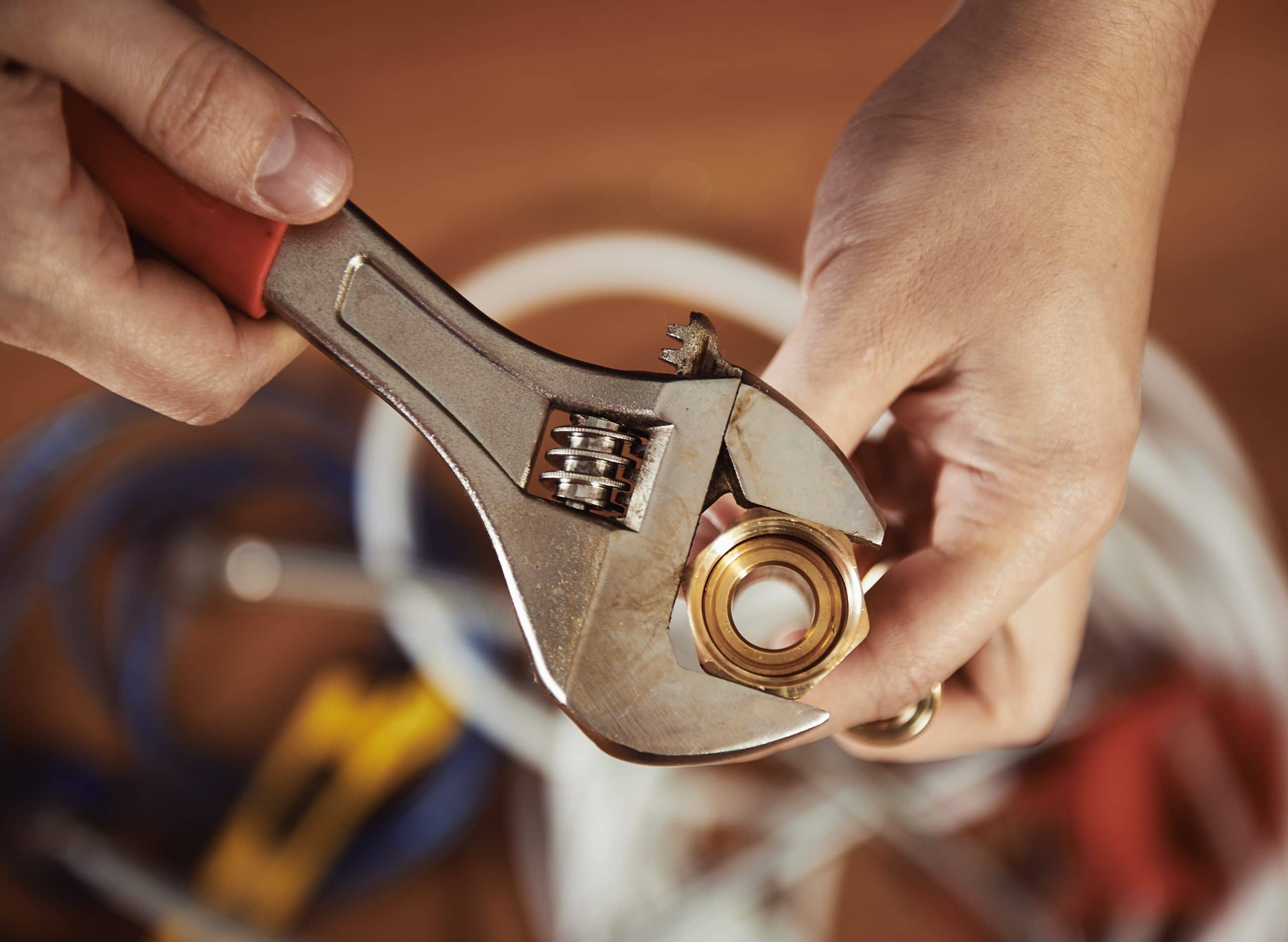 A plumber hands screwing nut of pipe with wrench over enterprise plumbing & gas